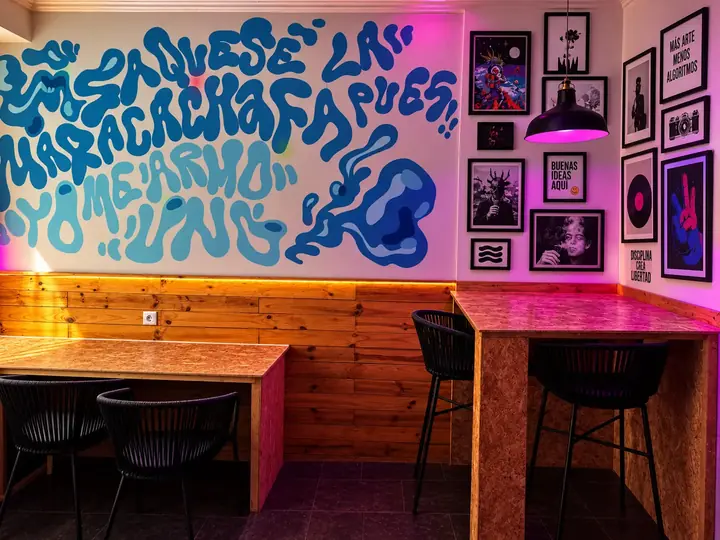 Mural azul, cuadros y mesas en Asociación Estigia, Chamberí